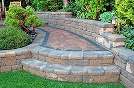 Stone steps and wall with lush landscaping.