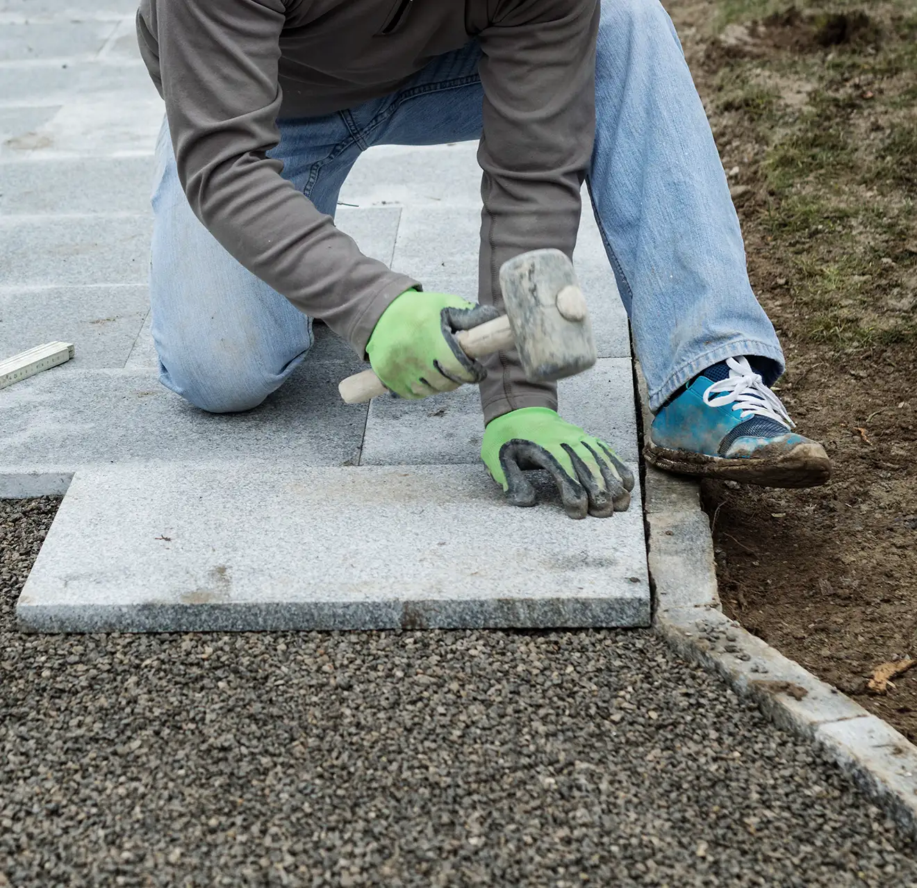 The Grounds Guys service professional installing pavers.