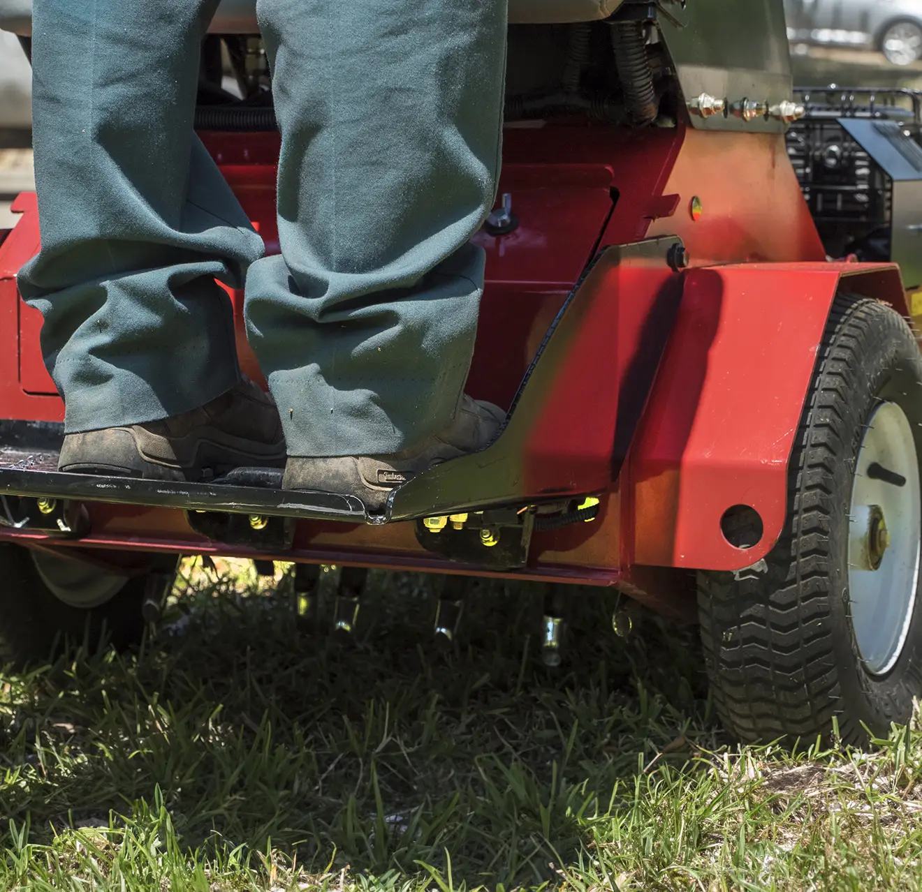 The back of a stand-on aerator in operation.