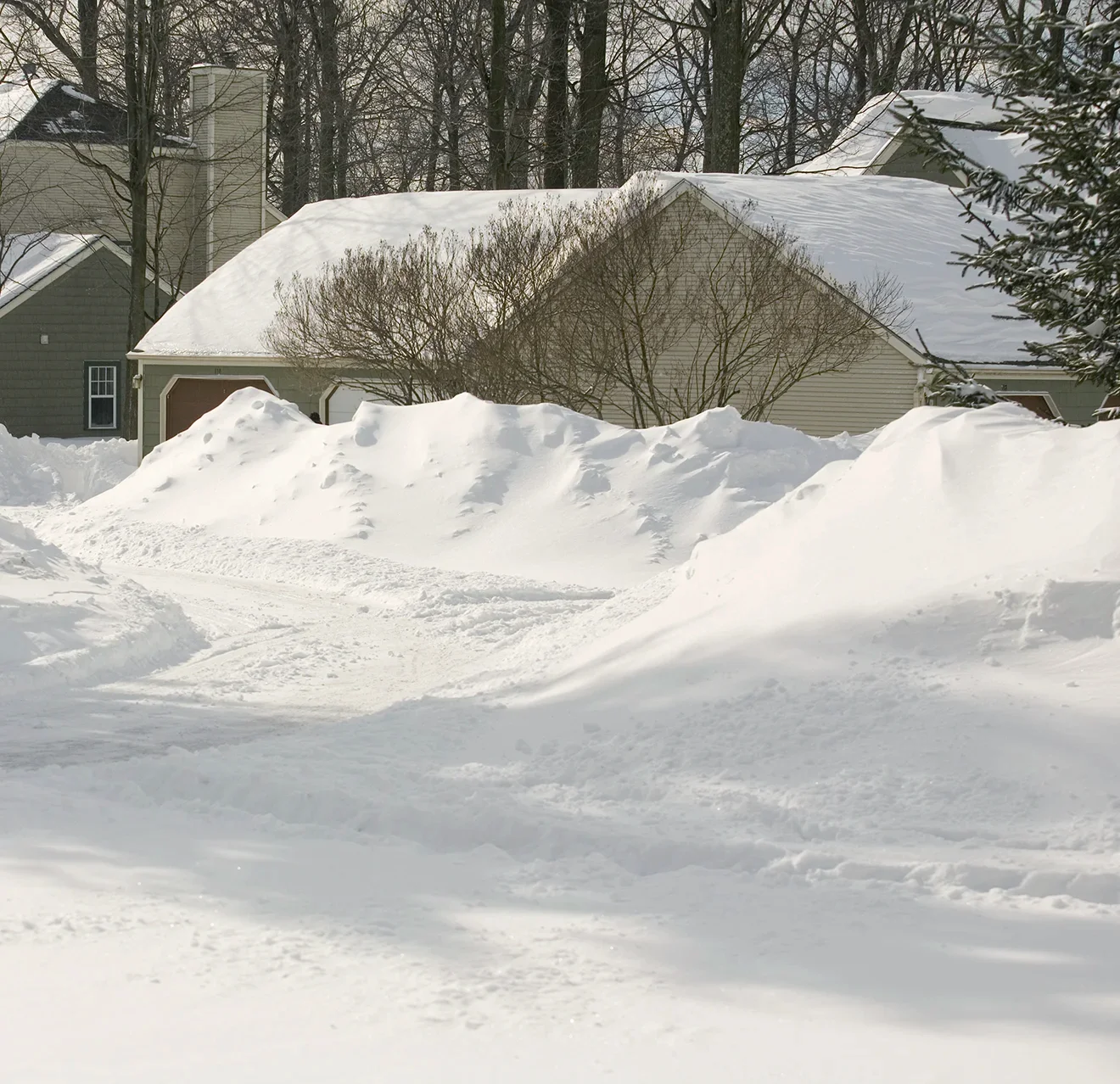 Tall piles of snow moved off the road in a residential cul-de-sac.