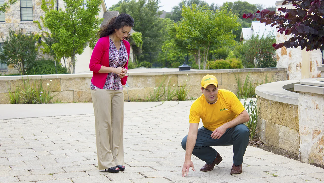 The Grounds Guys service professional showing a hardscape feature to a customer.