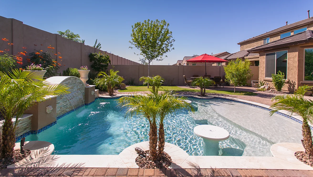 A beautiful residential pool with lush landscaping.