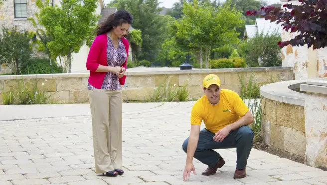 The Grounds Guys service professional consulting on a hardscape installation job with a customer.