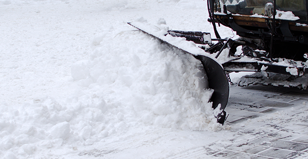 A snow plow pushing snow off a road.