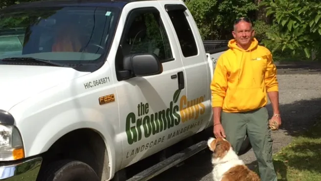 The Grounds Guys of Southbury owner T. Corby Hocker in front of truck.