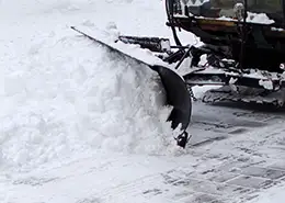 A snow plow pushing snow off a road. 