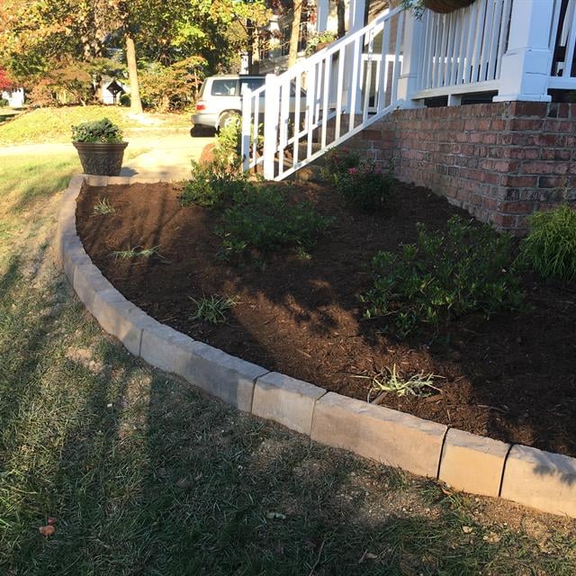 A side view of the garden with a stone border.