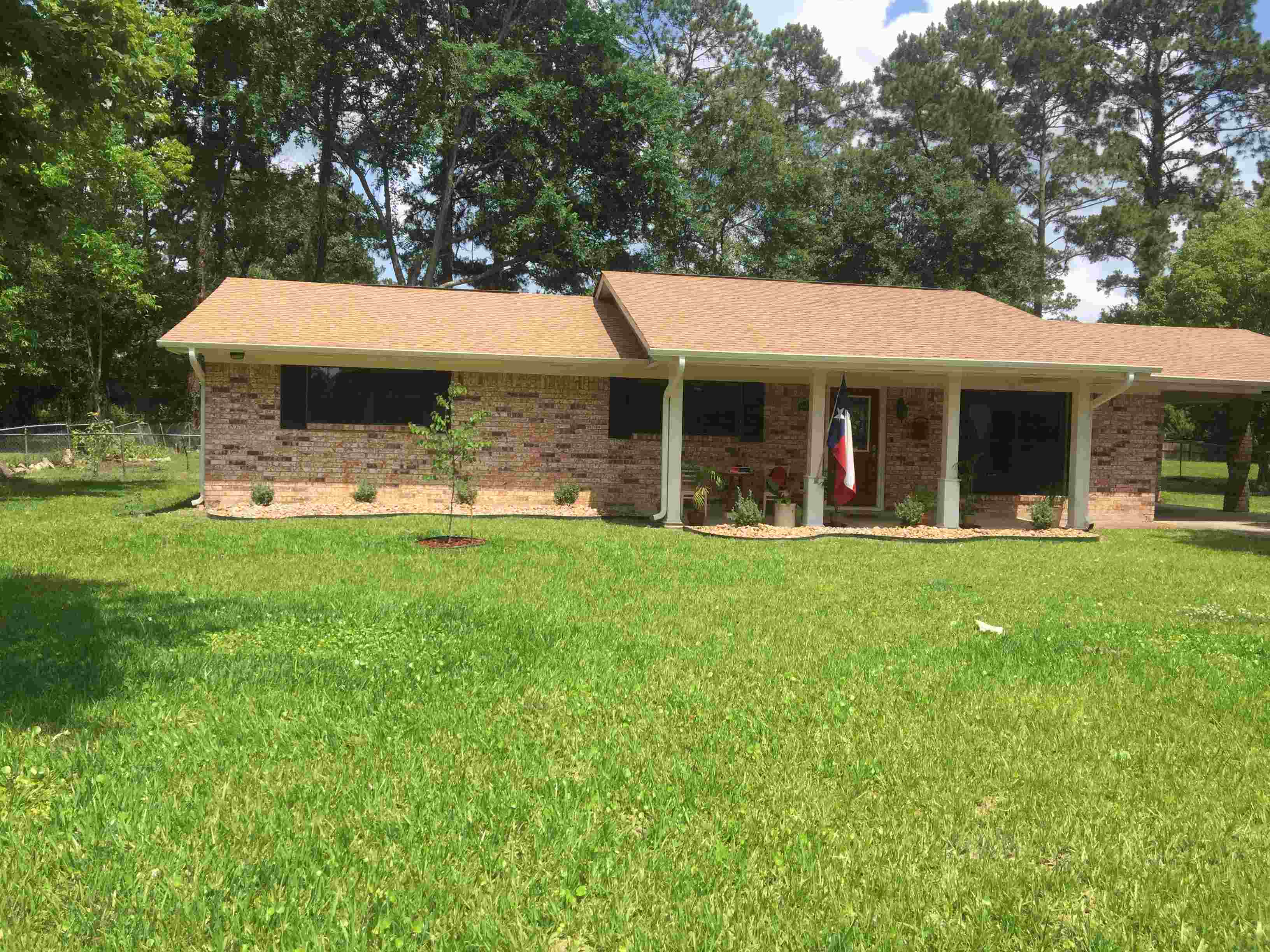 Brick house with tan roof and green yard