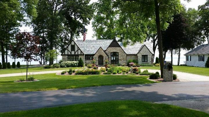 Well manicured lawn, driveway and planter in front of house