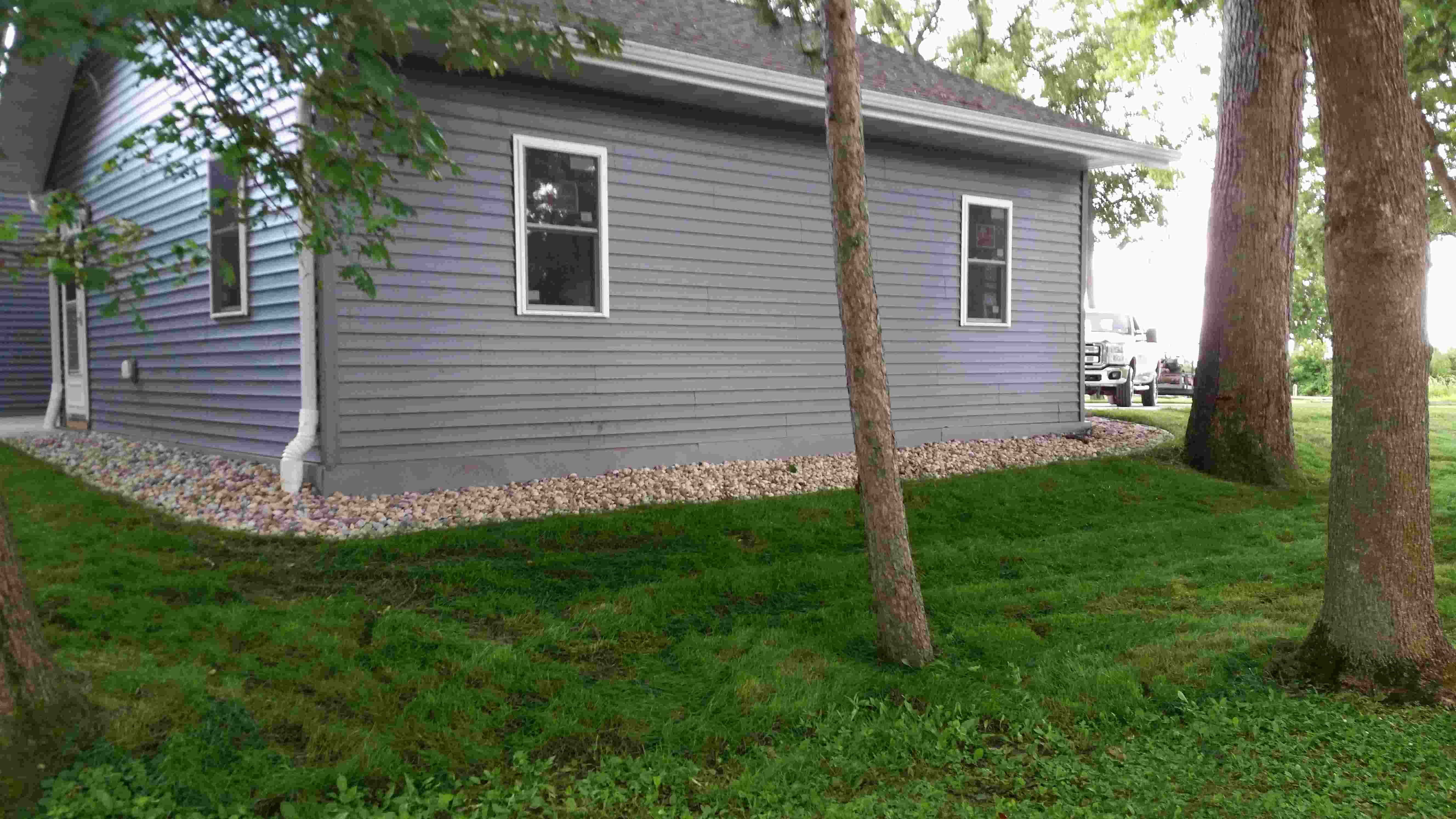 Side of house surrounded by gravel and well manicured lawn