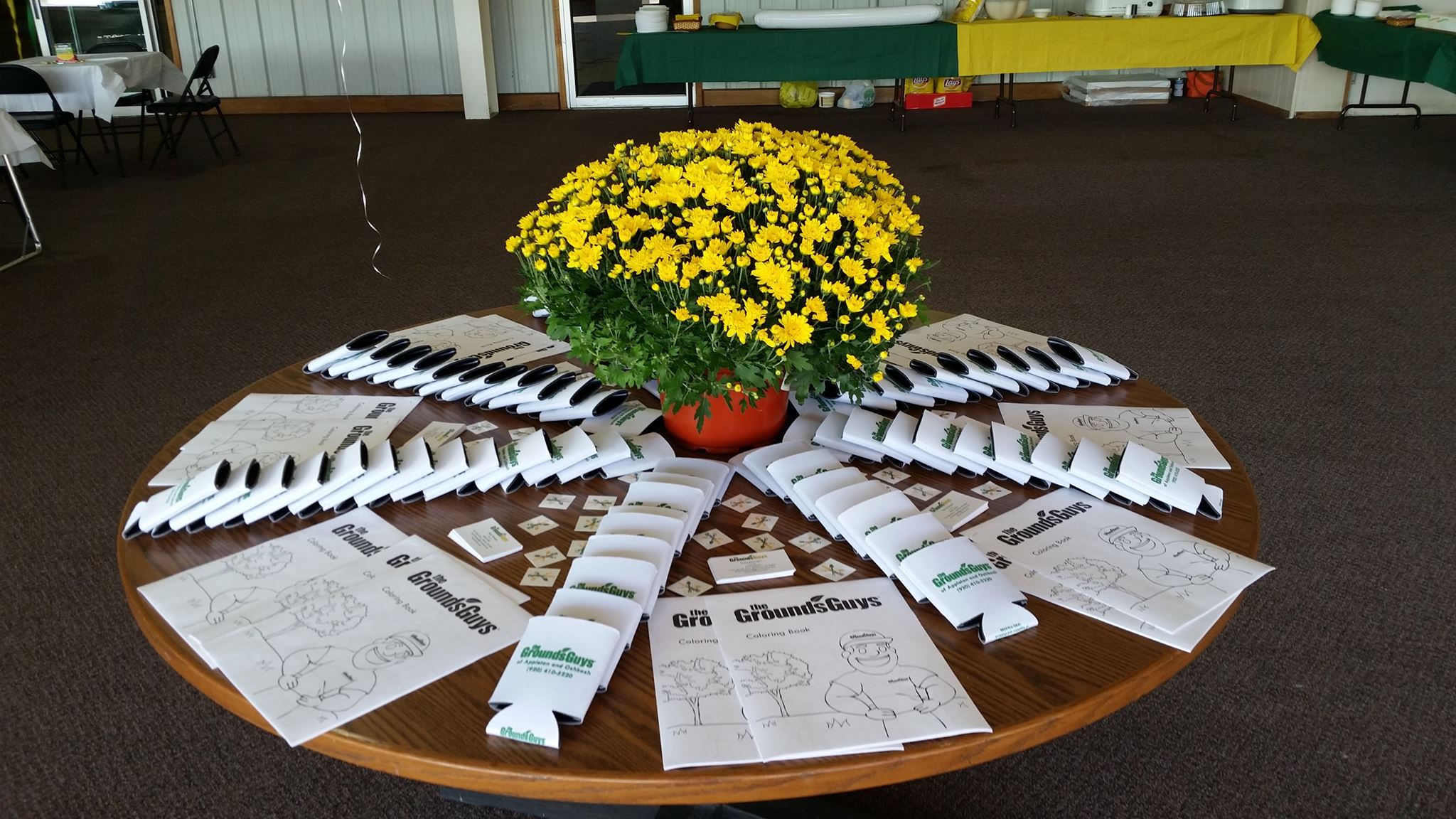 Flower pot surrounded by Grounds Guys branded items