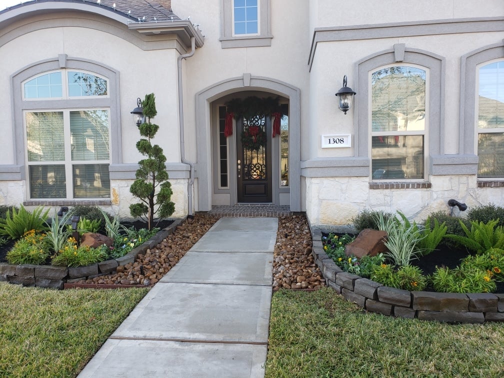 Gray home with cement walkway and grass lawn 