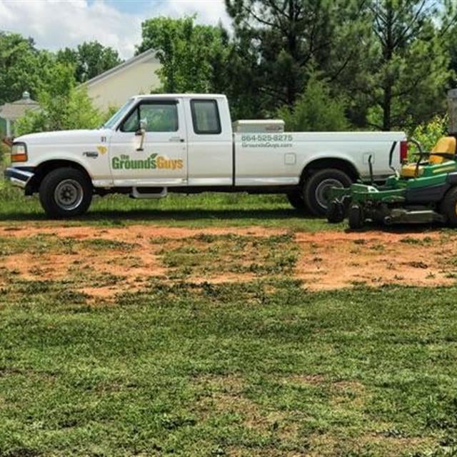 Ground Guys car parked on the green field.