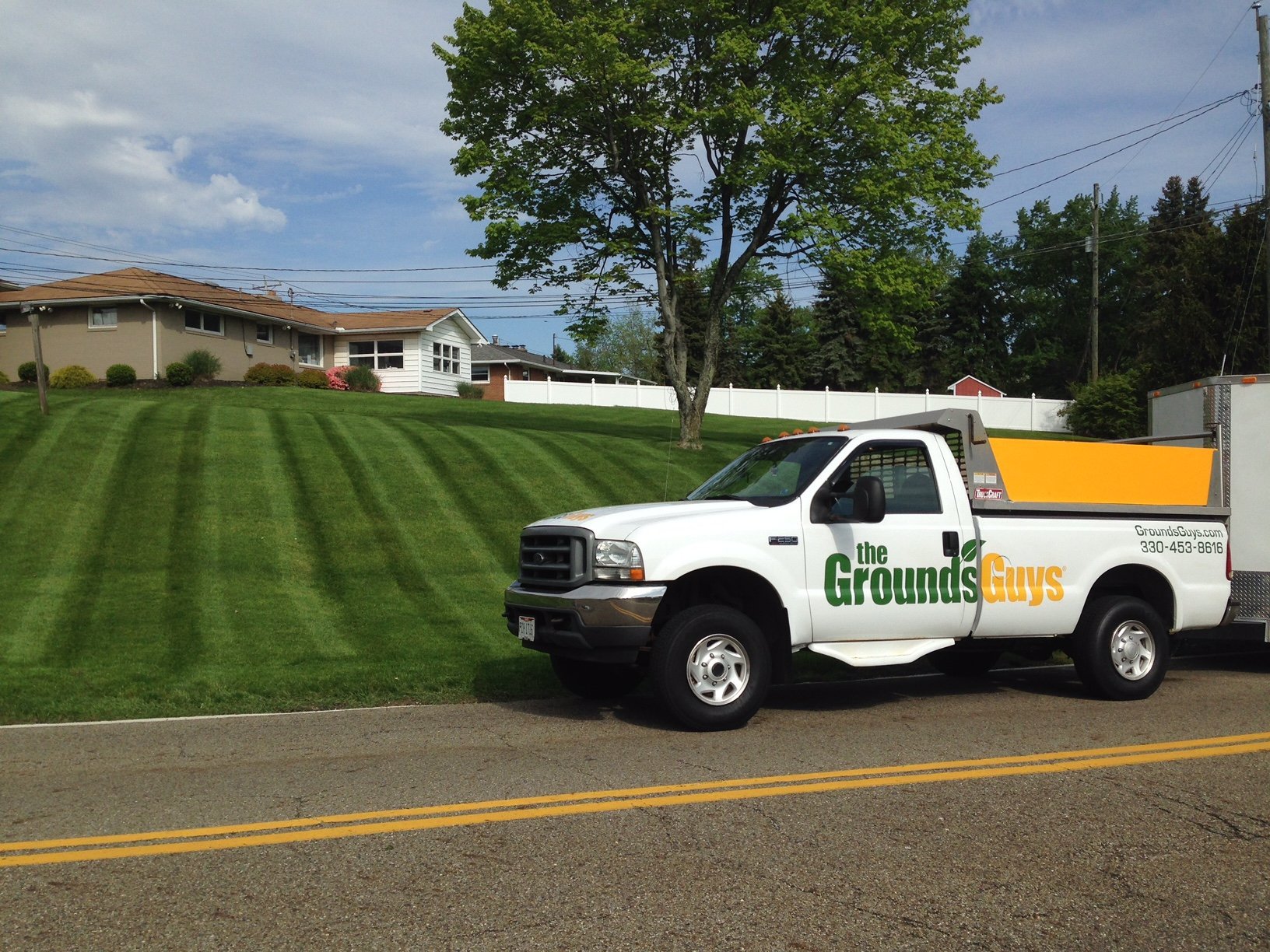 Grounds Guys truck and well manicured lawn