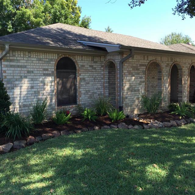 Lawn and stone landscape on the side of the brick house