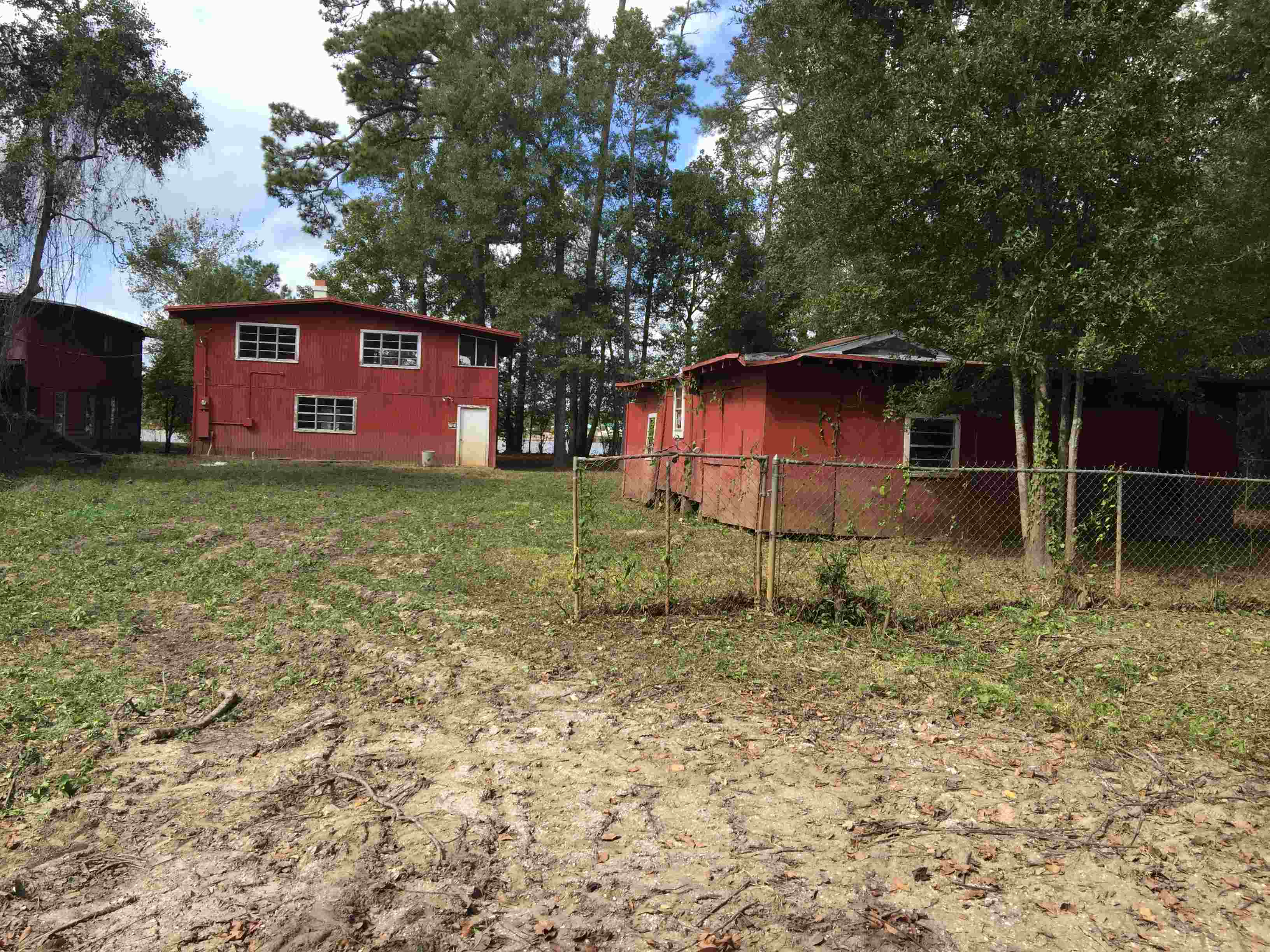 Red houses with fence and dilapidated yard