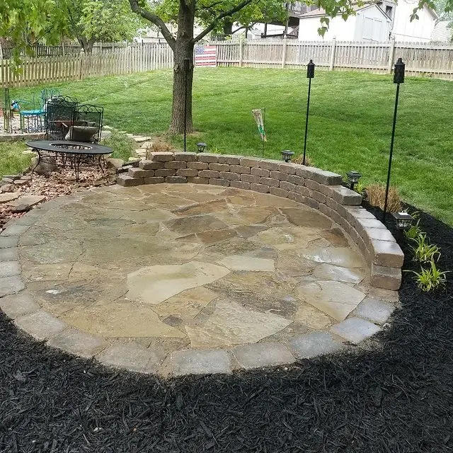 round patio area with tiki torches and fire pit