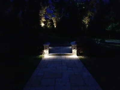 stone walkway lit by lights on pillars