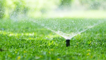 Automatic sprinkler watering a residential lawn