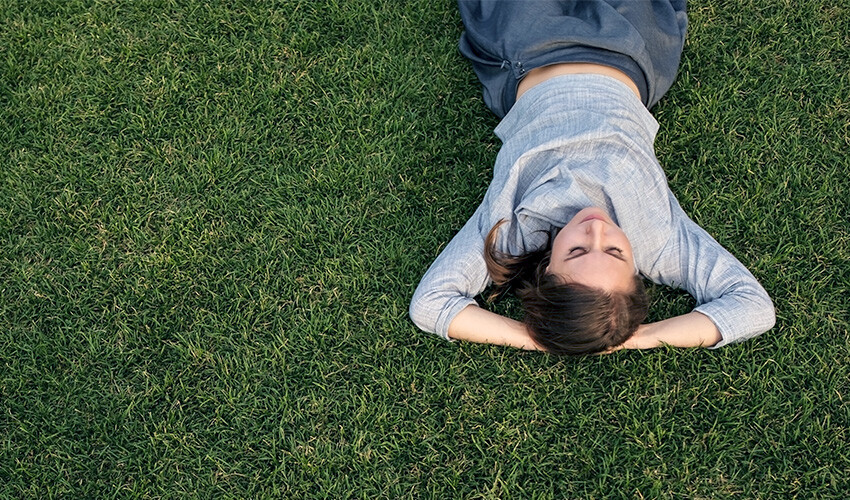 overseeded lush lawn with woman stretched out on it