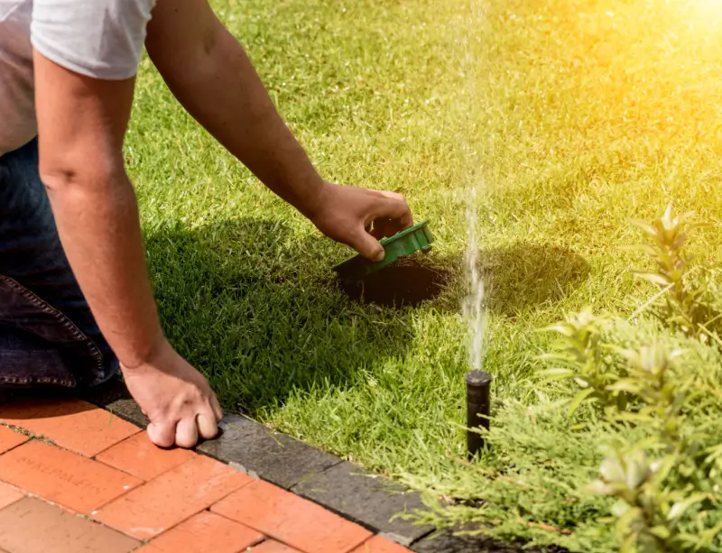 Landscaper performing maintenance on irrigation system