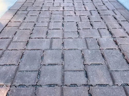 A walkway made of permeable pavers with gravel drainage substrate below.