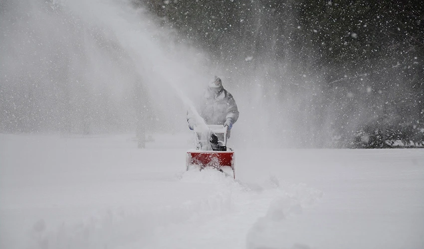 person pushing snow plow